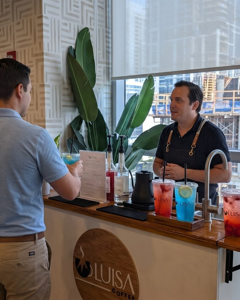 Guests at a corporate event talking with the barista at the Miami Refresher Cart