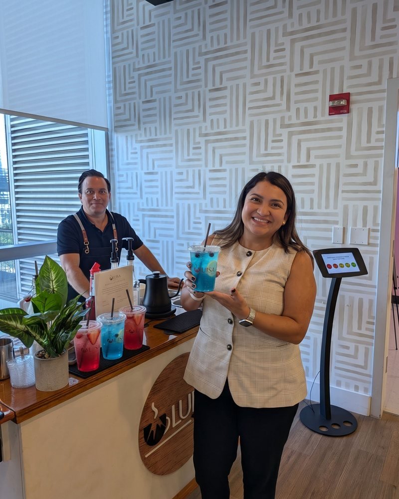 A guest holding a blue refresher next to the barista at the Miami Refresher Cart